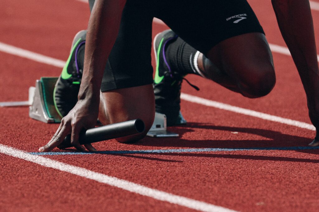 The legs of a runner, poised to start a race.